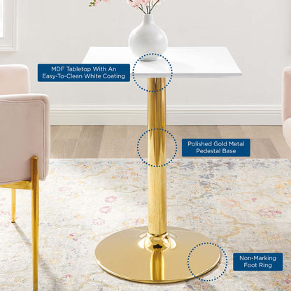 White square MDF tabletop with easy-clean coating on a polished gold pedestal base with round foot ring; modern dining table.