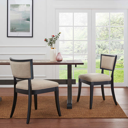 Pair of dark wood dining chairs with beige upholstered fabric seats, on a brown jute rug.