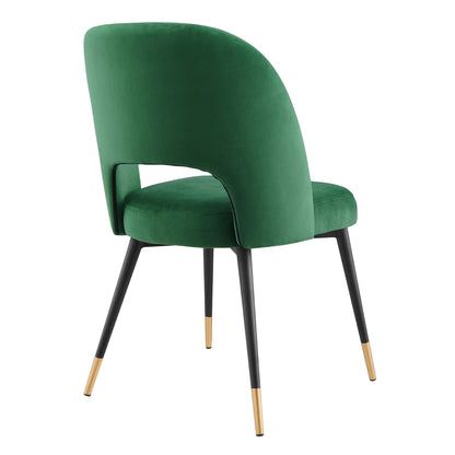 Emerald green velvet dining chairs with curved backs, cushioned seats, black legs & gold tips (set of 2).