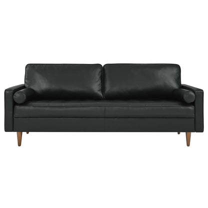 Black leather sofa with two back cushions, cylindrical arm bolsters, and wood tapered legs in a mid-century style.