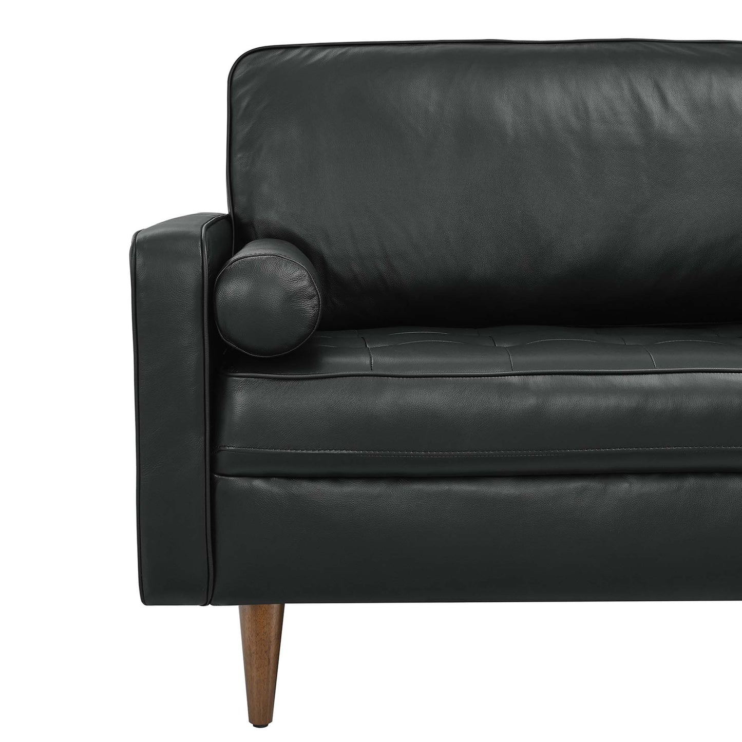 Black leather mid-century modern sofa with tufted cushions, a round bolster on the arm, and tapered wooden legs.