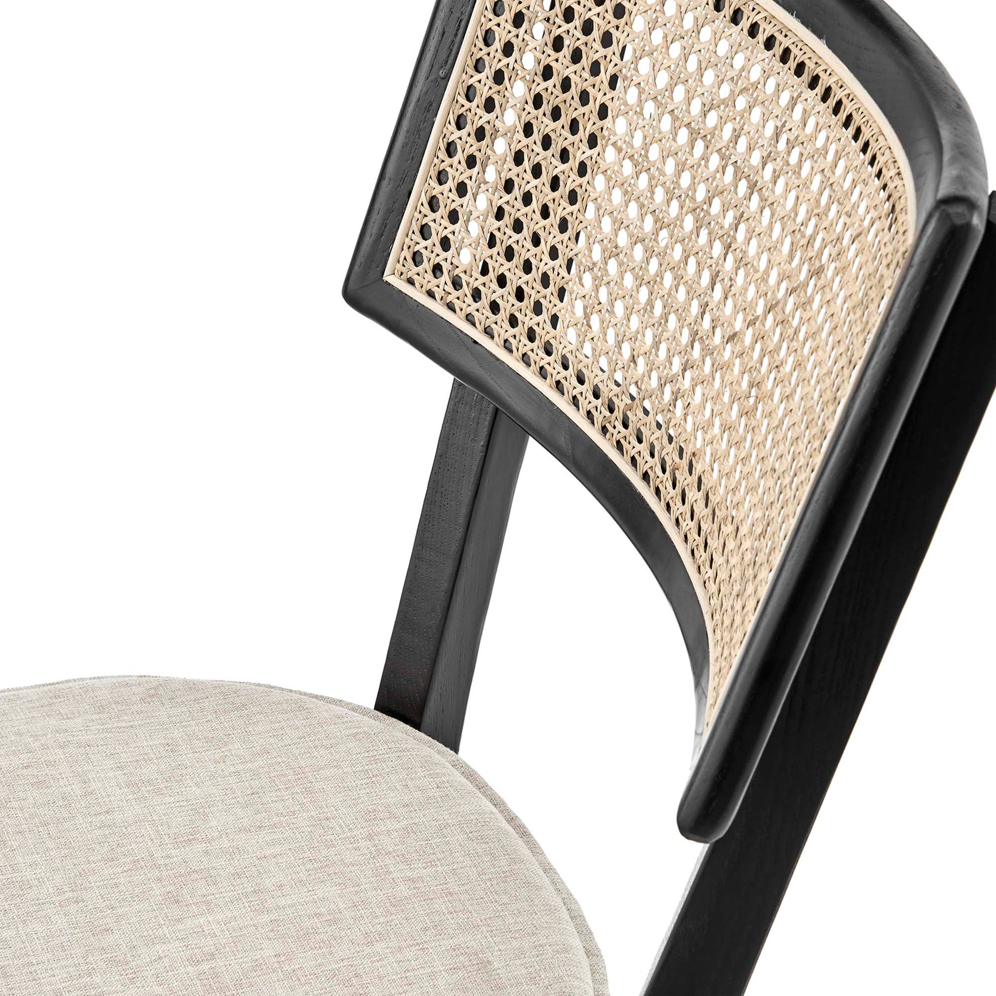 Black wood dining chair with woven cane back & beige fabric seat.