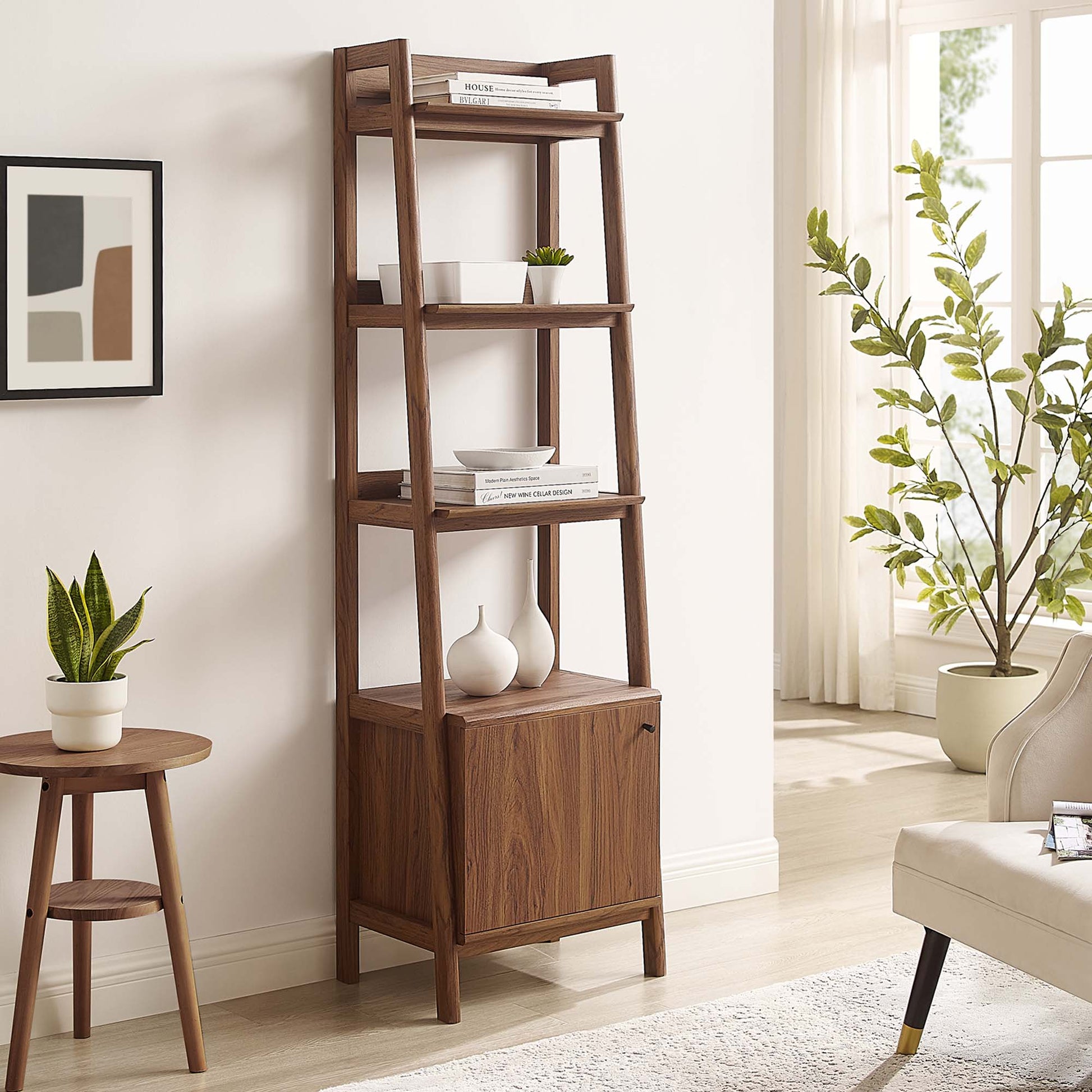 Walnut wood ladder bookshelf with open shelves and a cabinet base, styled with vases and books in a bright living room.