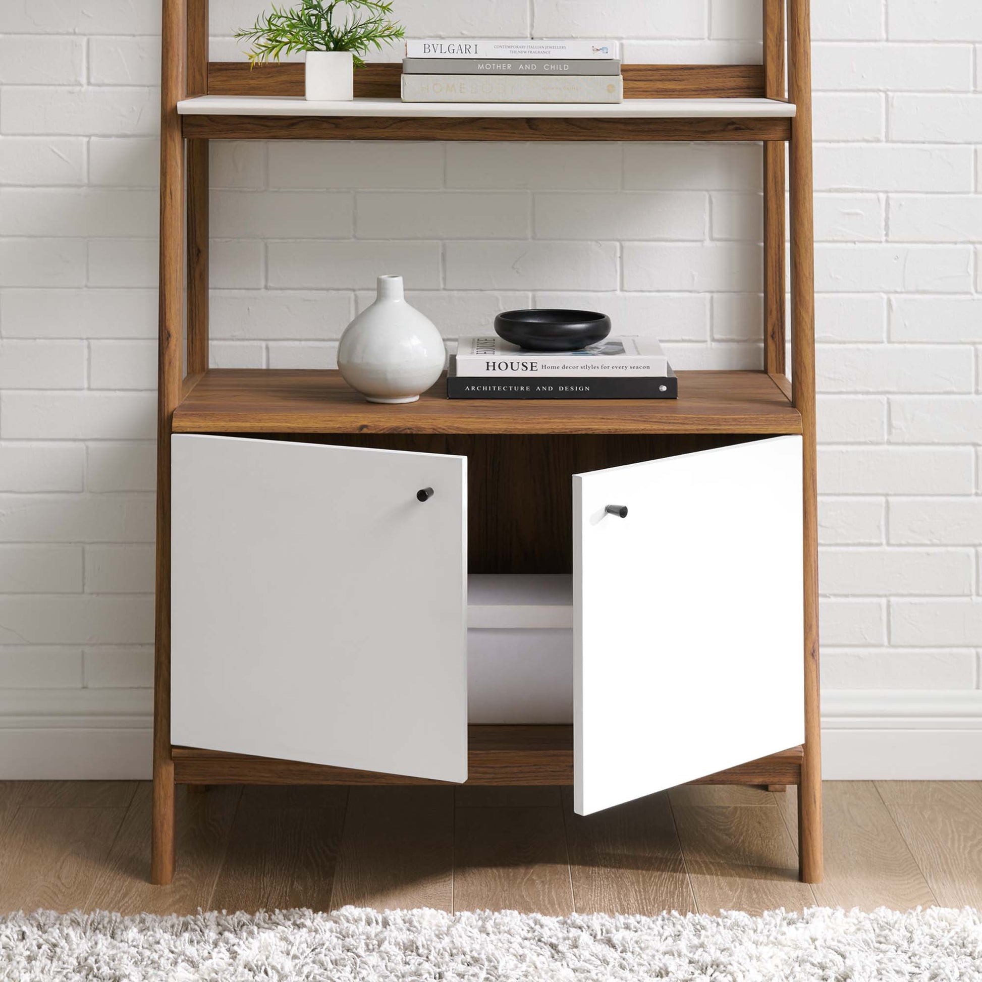 White bookshelf with two cabinet doors and black knobs, mid-century modern display for books and decor.