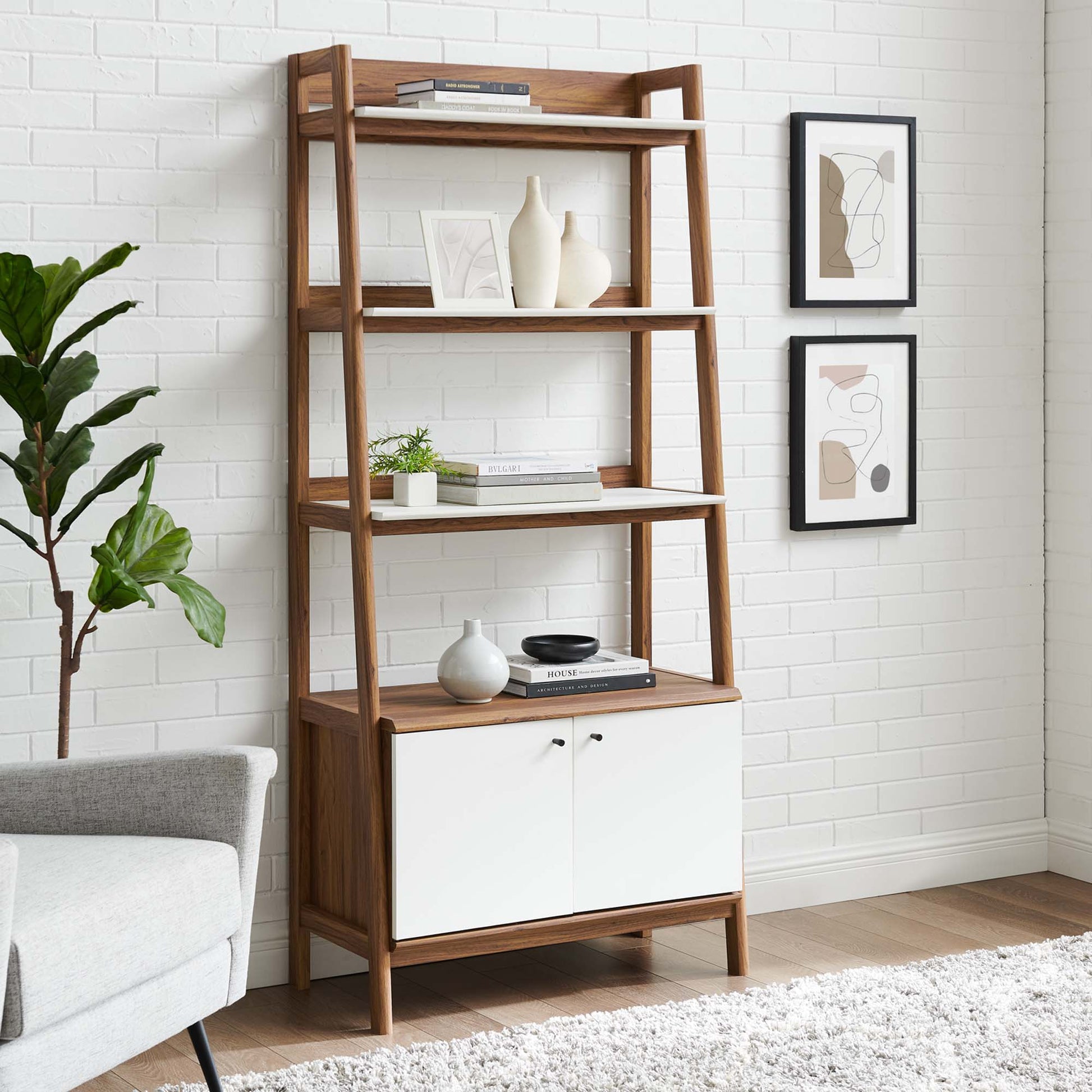 White bookshelf with cabinet doors, decorative vases, books, a plant, and framed art in a bright living room.