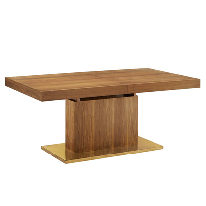 Walnut dining table with two-leaf top and gold pedestal base on gold platform.
