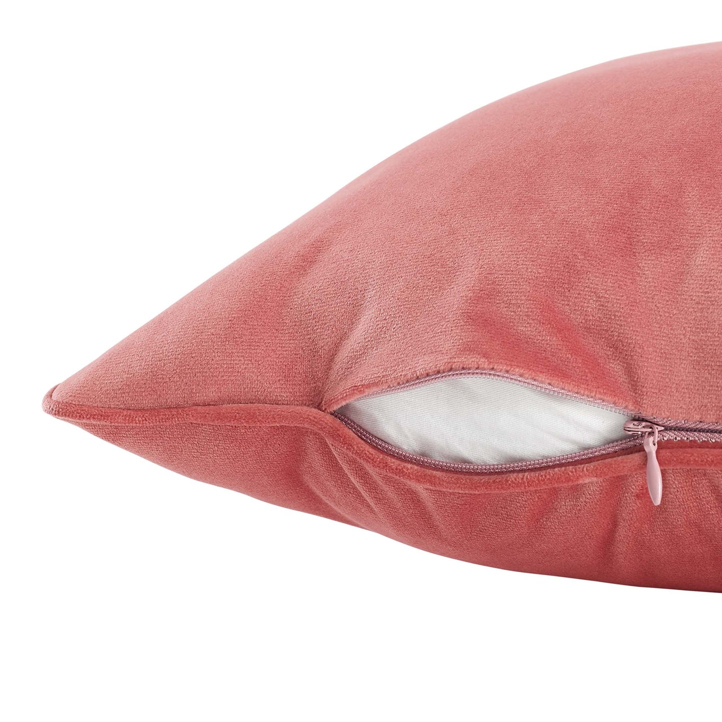 Coral velvet pillow with zipper, partially open to reveal white inner filling.