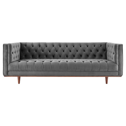 Grey velvet tufted sofa with button-tufted back, slim arms, and wooden tapered legs in mid-century style.