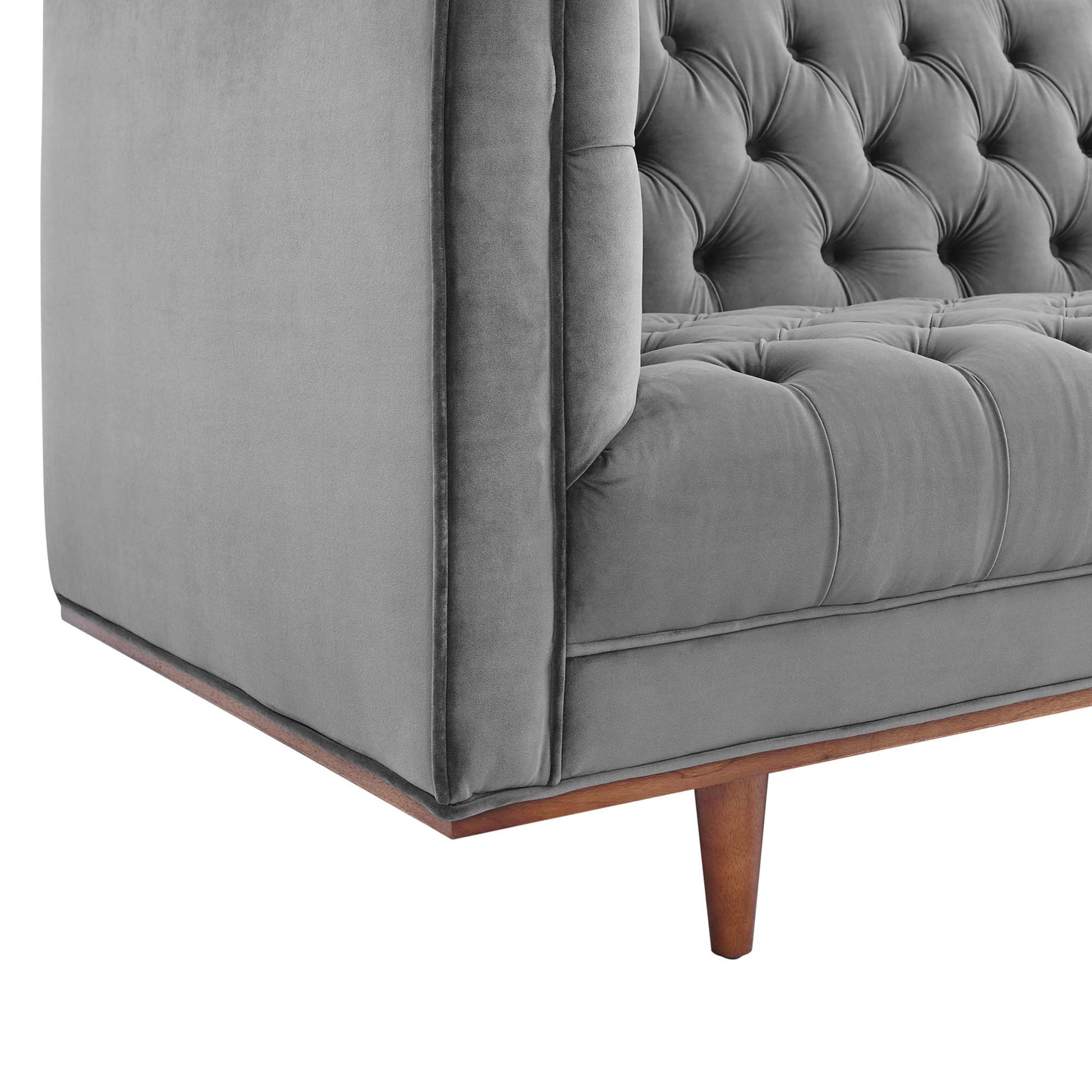 Grey velvet tufted sofa with button-tufted back and seat, wooden tapered legs.