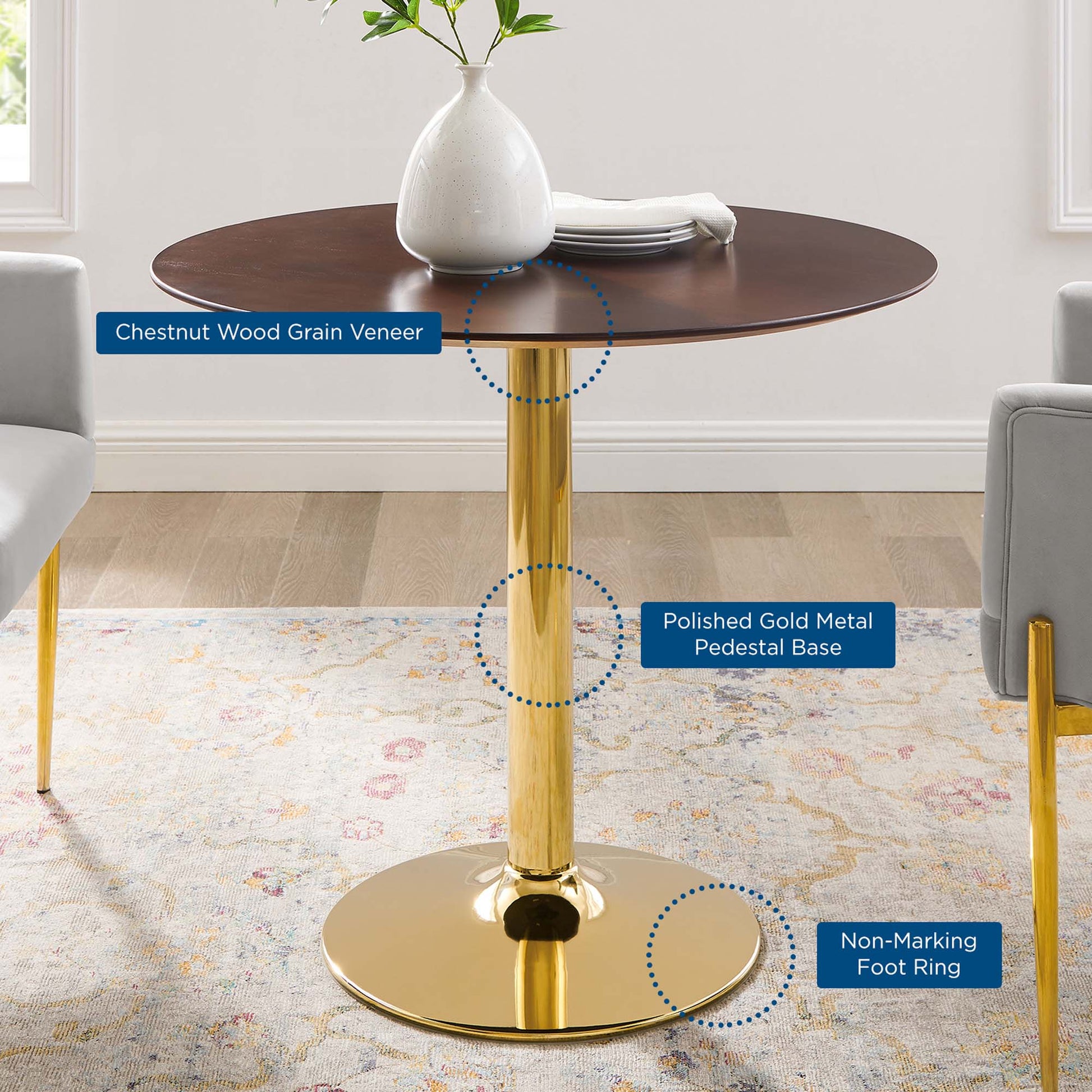 Round table with chestnut wood veneer top, polished gold pedestal base, and non-marking foot ring; modern glam design.