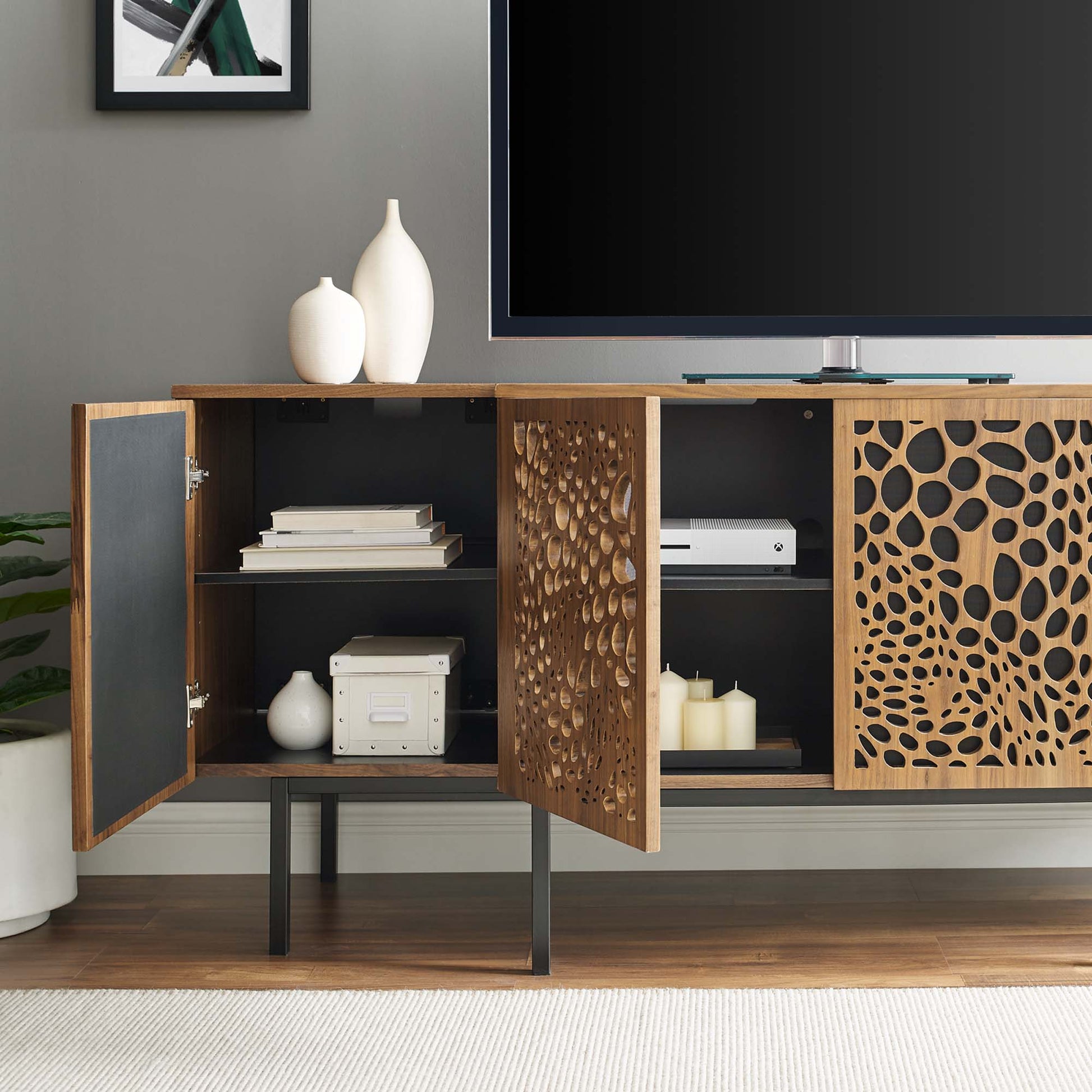 Walnut veneer sideboard with decorative circular perforated doors, black interior, metal legs and storage shelves.