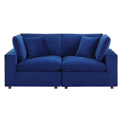Navy velvet loveseat with plush cushions, square arms, and wooden legs.