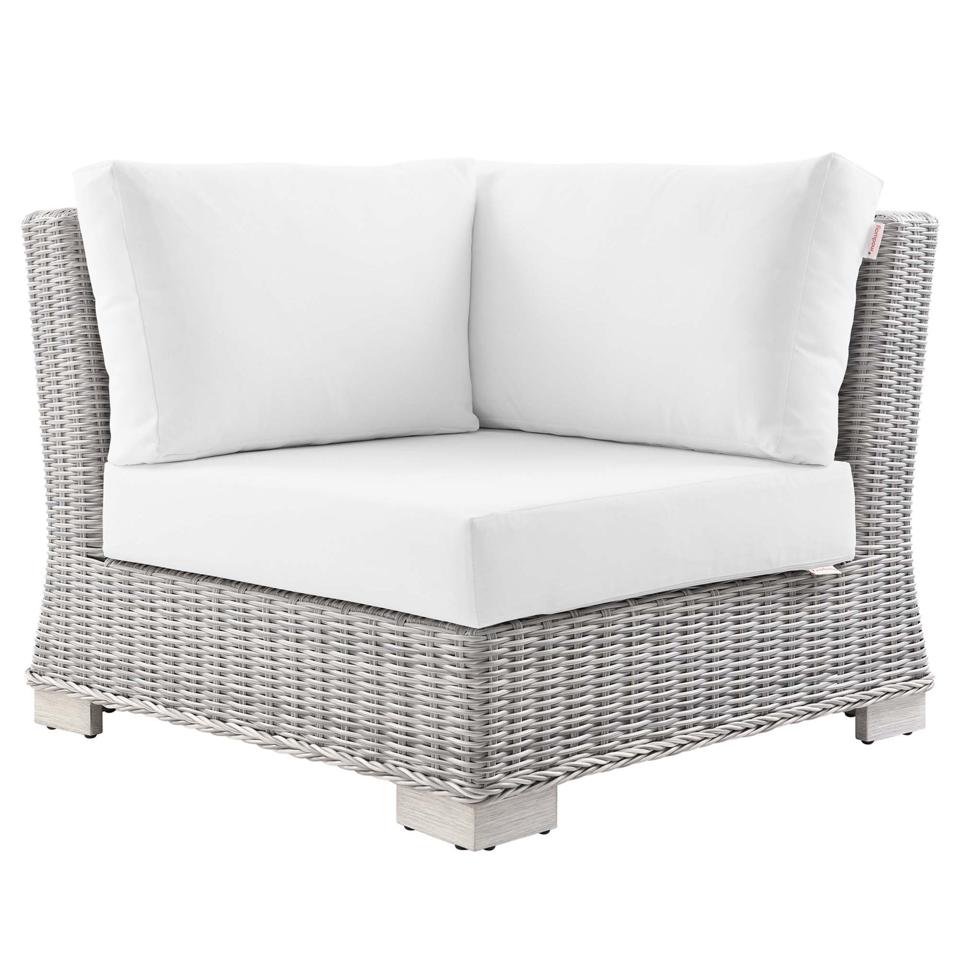 Light gray wicker outdoor corner chair with white cushions & square wooden feet.