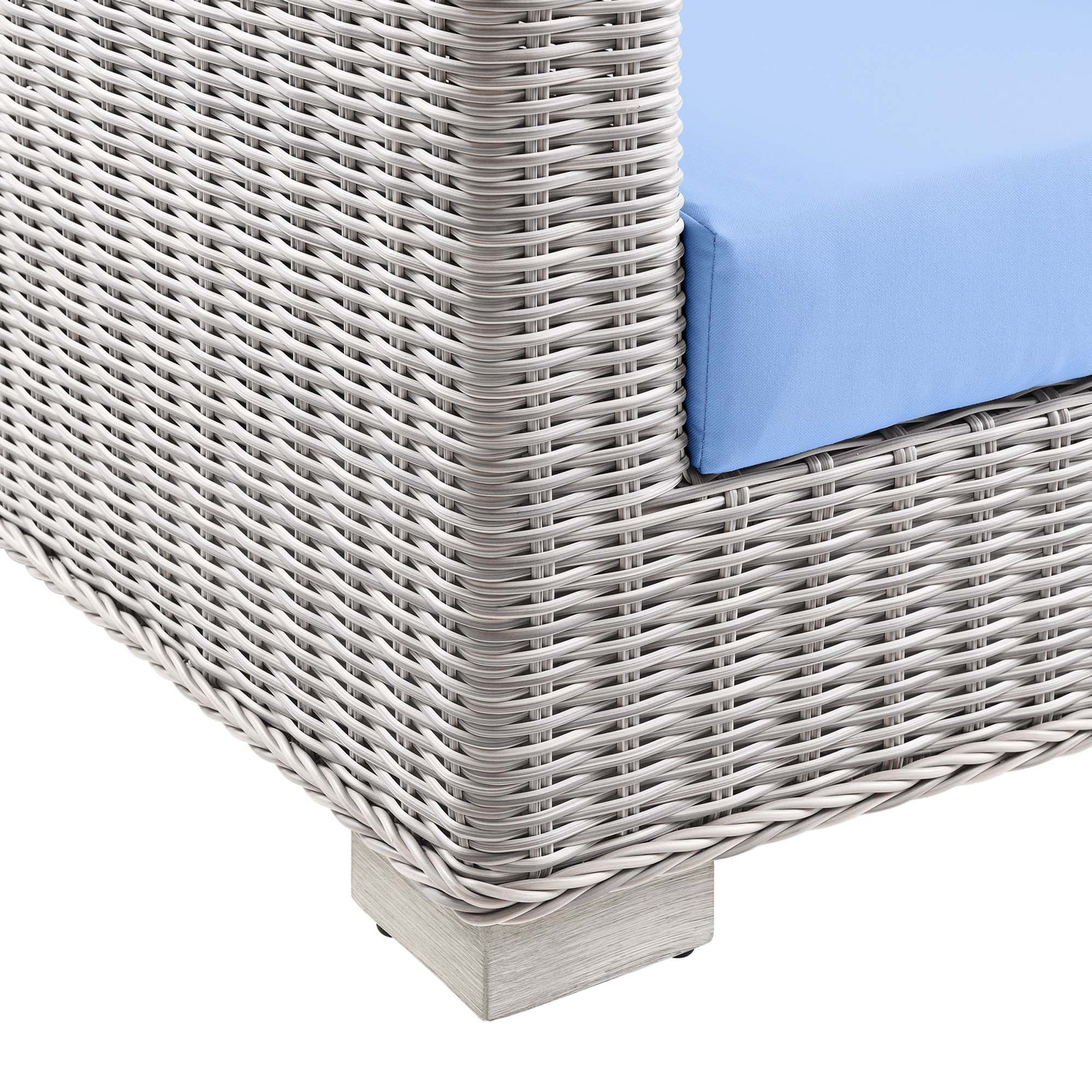 Gray woven rattan outdoor loveseat with a light blue cushion and a square gray pedestal base