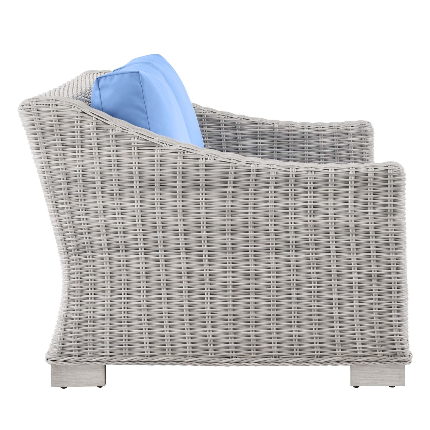 Grey wicker outdoor loveseat with blue fabric cushions, curved armrests and sturdy block legs.