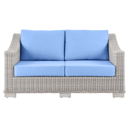 Beige woven rattan outdoor 2-seat sofa with sky-blue cushions and back pillows