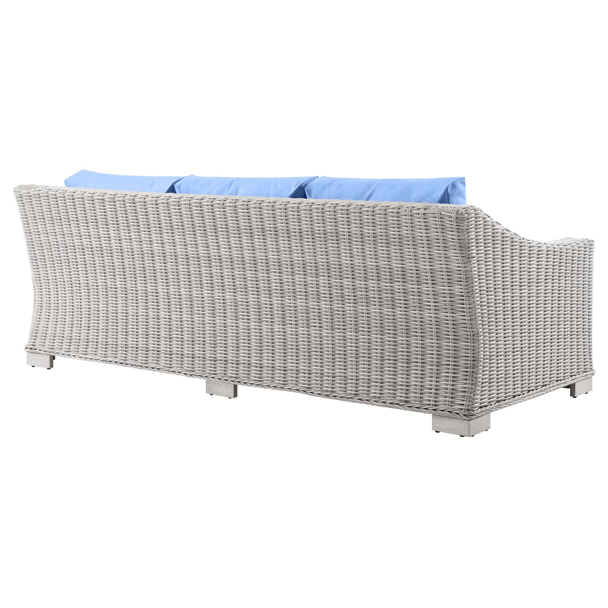 Light gray wicker outdoor sofa with blue cushions, curved back and square block feet.