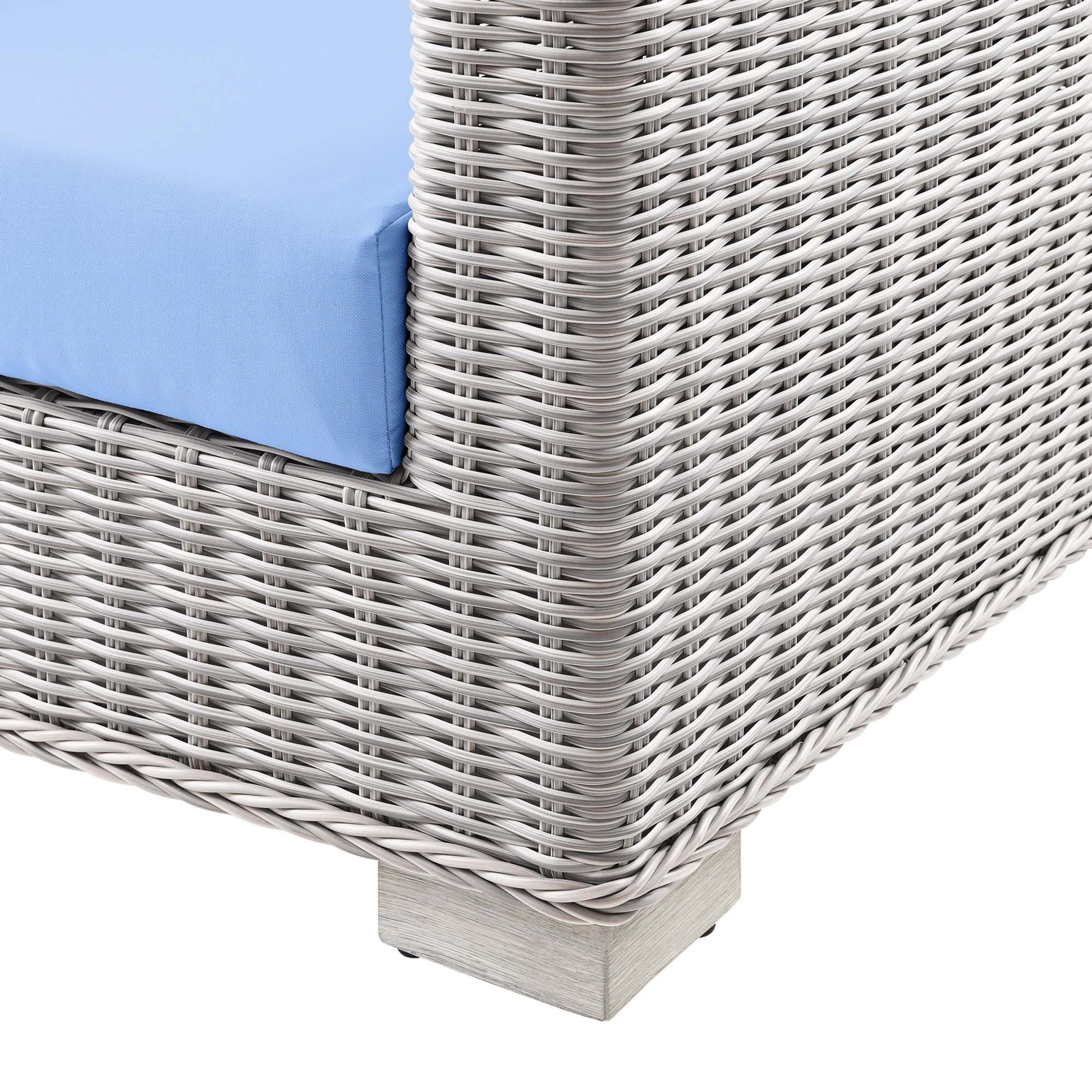Gray woven synthetic rattan outdoor sofa with blue cushion and light wood base