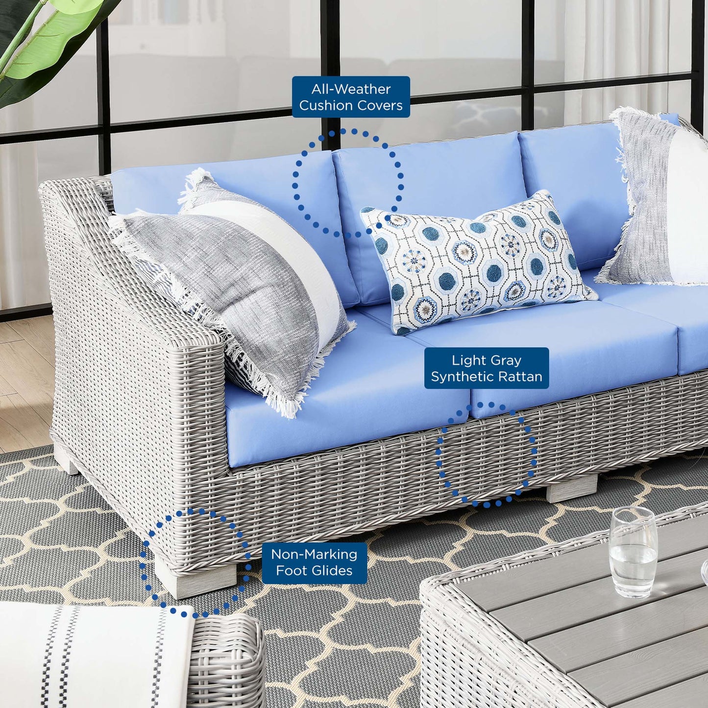 Outdoor wicker sofa with light-blue cushions, gray synthetic rattan, all-weather cushion covers, and non-marking foot glides.