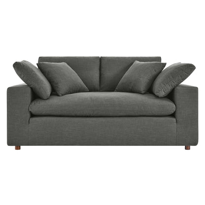 Gray fabric loveseat with square arms, loose back cushions & matching pillows, wooden legs.