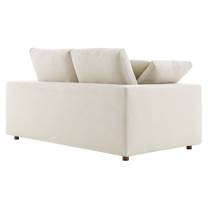 Beige loveseat with square arms and wooden legs; two back cushions and down-filled, overstuffed cushions.