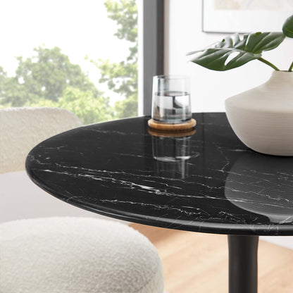 Round black faux marble top dining table with white veining and a slim pedestal base in a modern dining room.