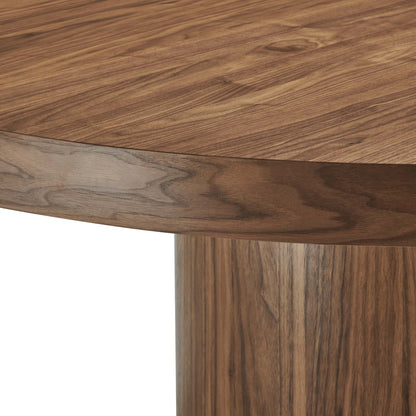 Round walnut wood dining table with curved edge and single pedestal leg, warm natural grain.