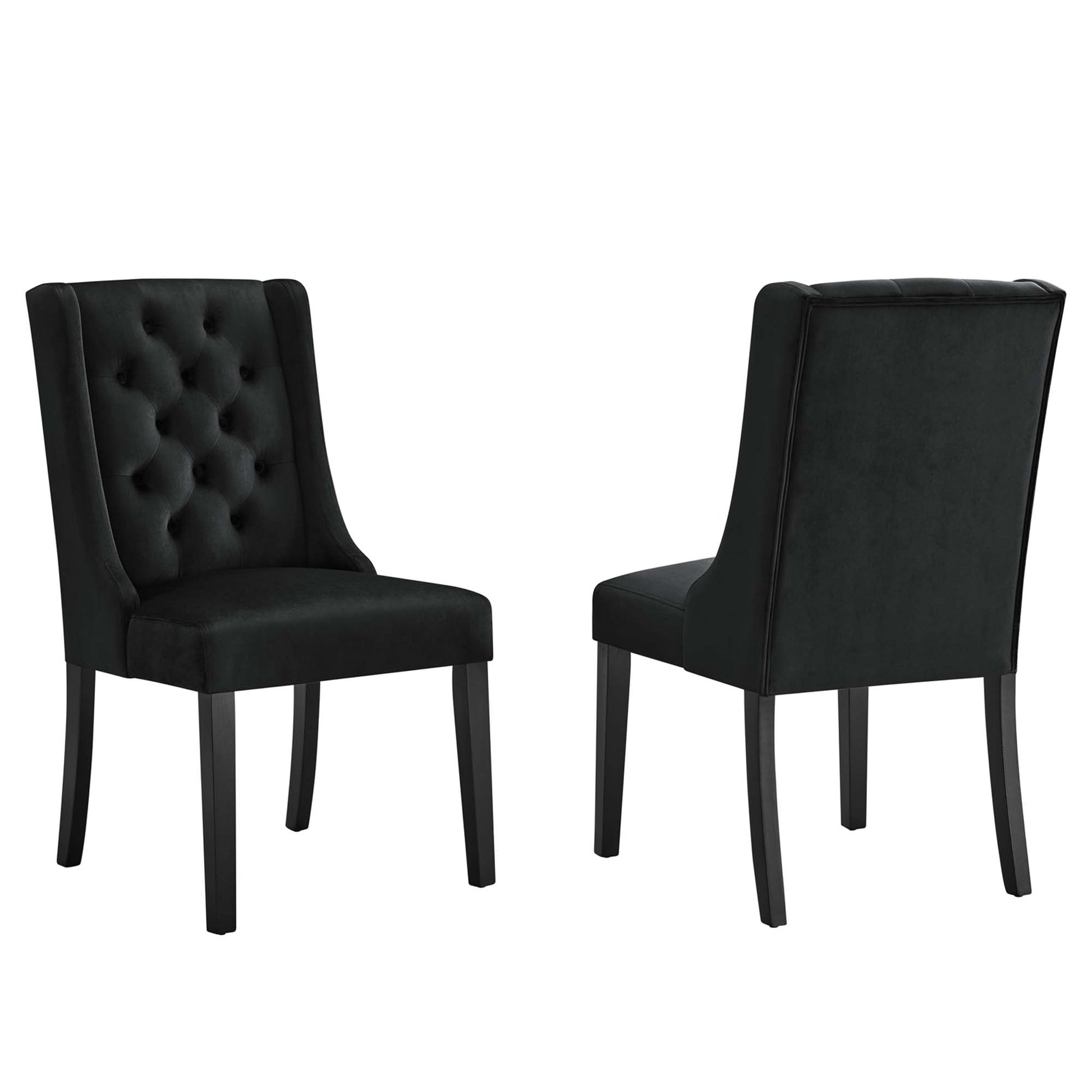 Pair of black tufted velvet dining chairs with tall curved backs & dark wooden legs.