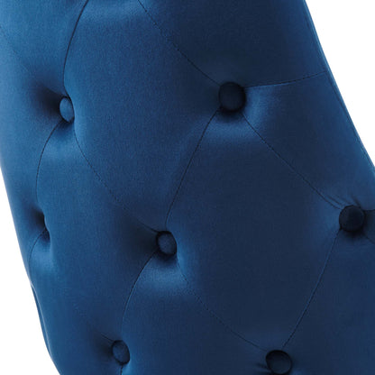 Close-up of navy blue tufted velvet upholstery with round buttons in a diamond pattern.
