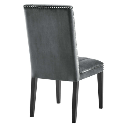 Rear view of gray upholstered dining chairs with silver nailhead trim and dark wooden legs (set of 2).