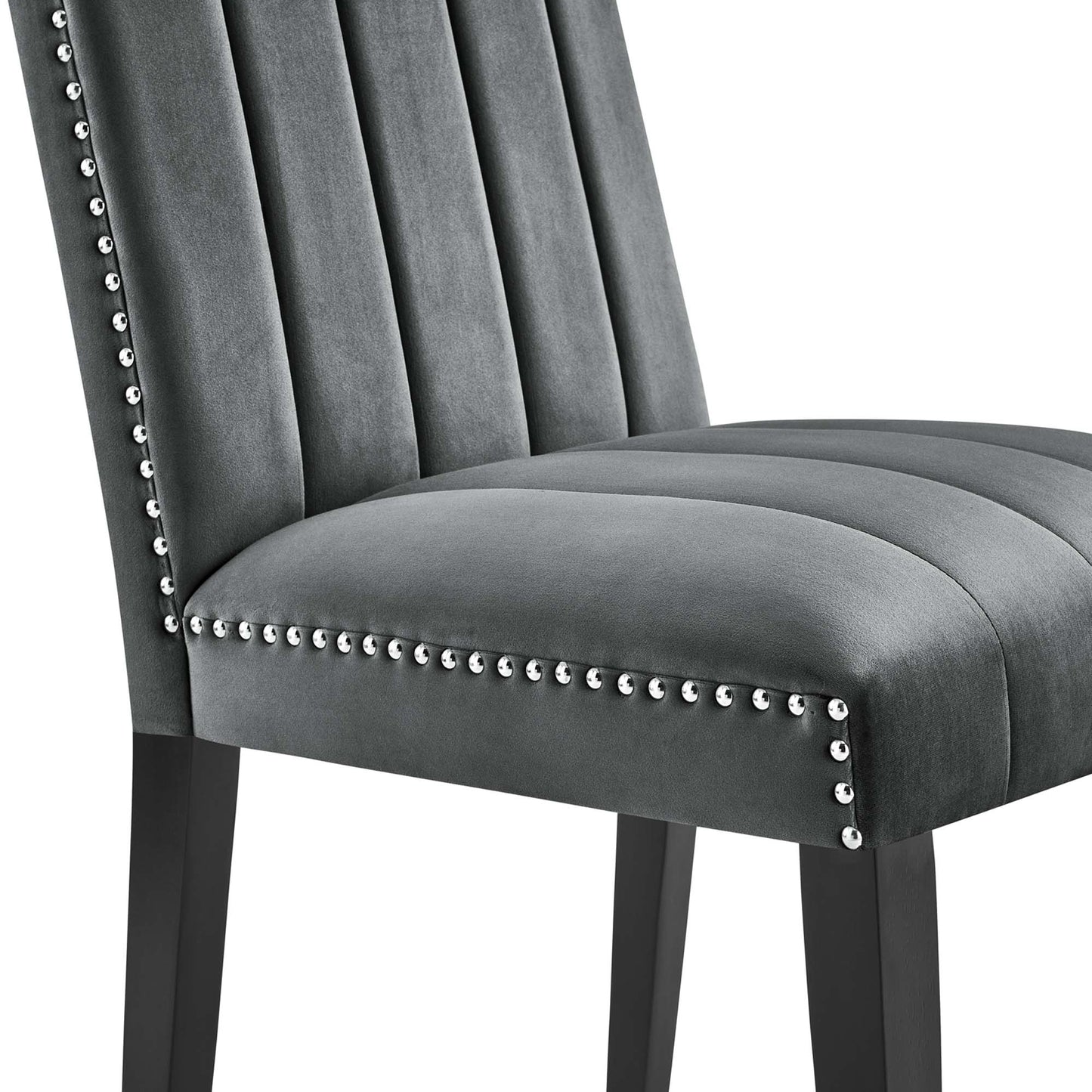 Gray velvet upholstered dining chairs with vertical channel tufting, nailhead trim along edges & dark wood legs.