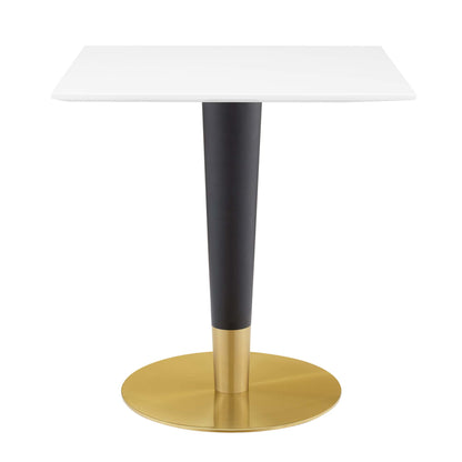 White square top dining table with black tapered stem and gold circular base, modern design.