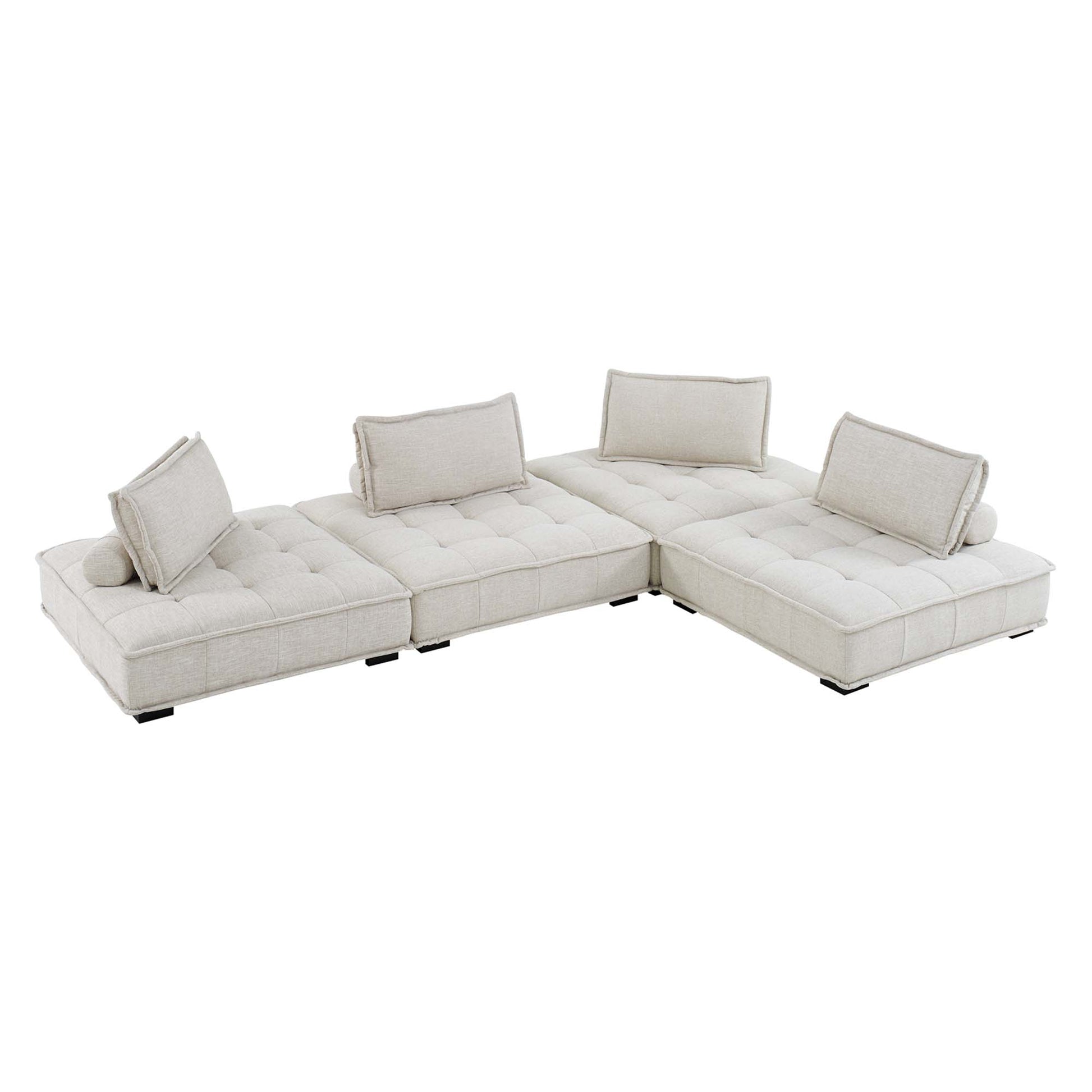 Beige fabric modular sectional sofa in L-shape with tufted cushions, bolster pillows, low legs.