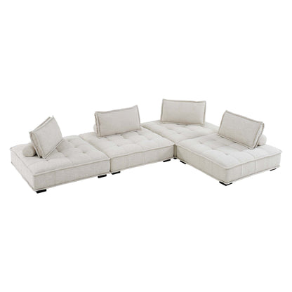 Beige fabric modular sectional sofa in L-shape with tufted cushions, bolster pillows, low legs.