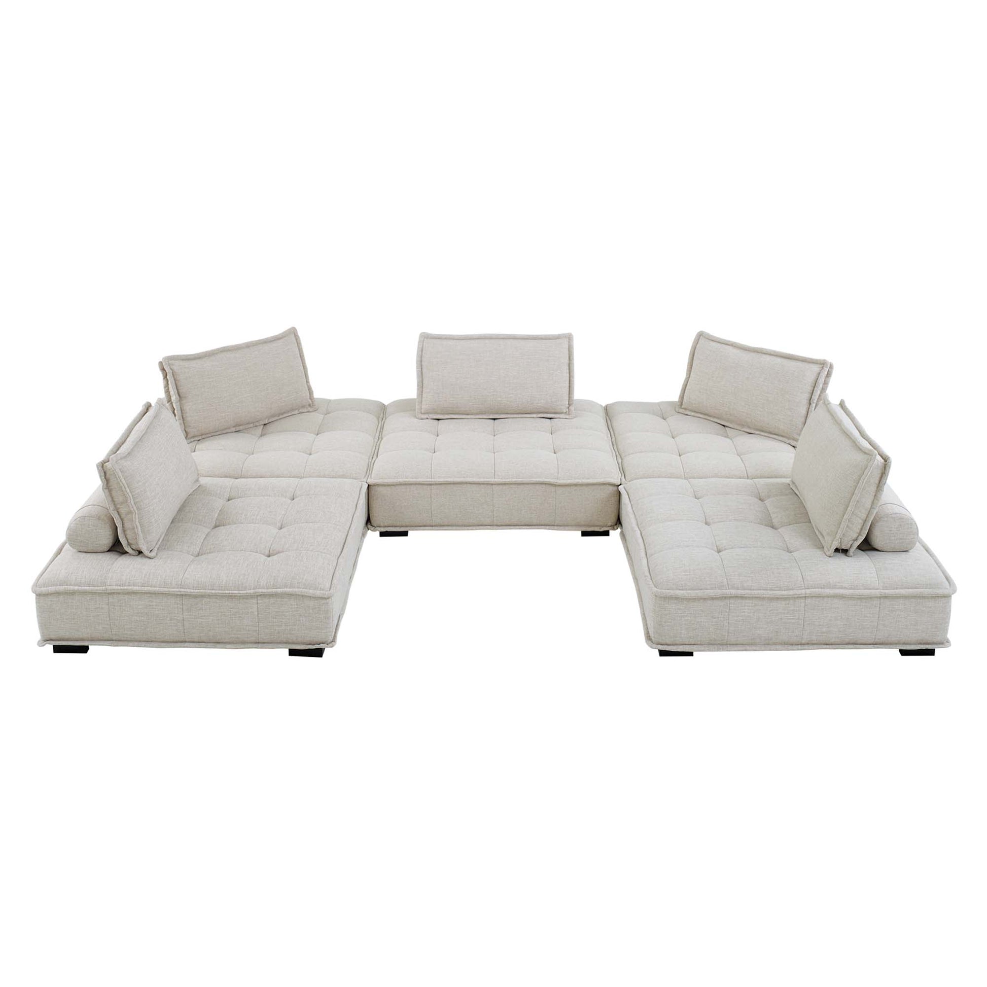 Beige fabric modular sectional with tufted cushions, U-shaped layout and bolster pillows for a modern living room.