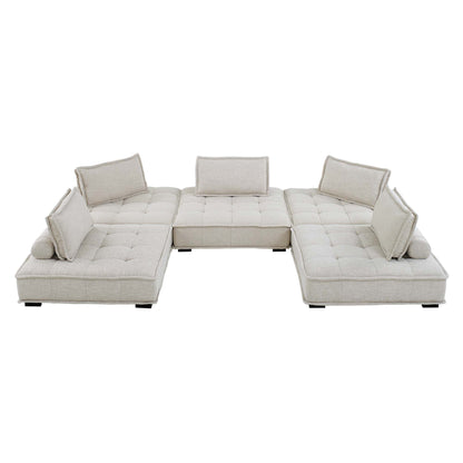 Beige fabric modular sectional with tufted cushions, U-shaped layout and bolster pillows for a modern living room.