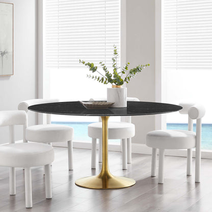 Round faux marble dining table on a gold pedestal base with white upholstered dining chairs in a modern glam dining room.