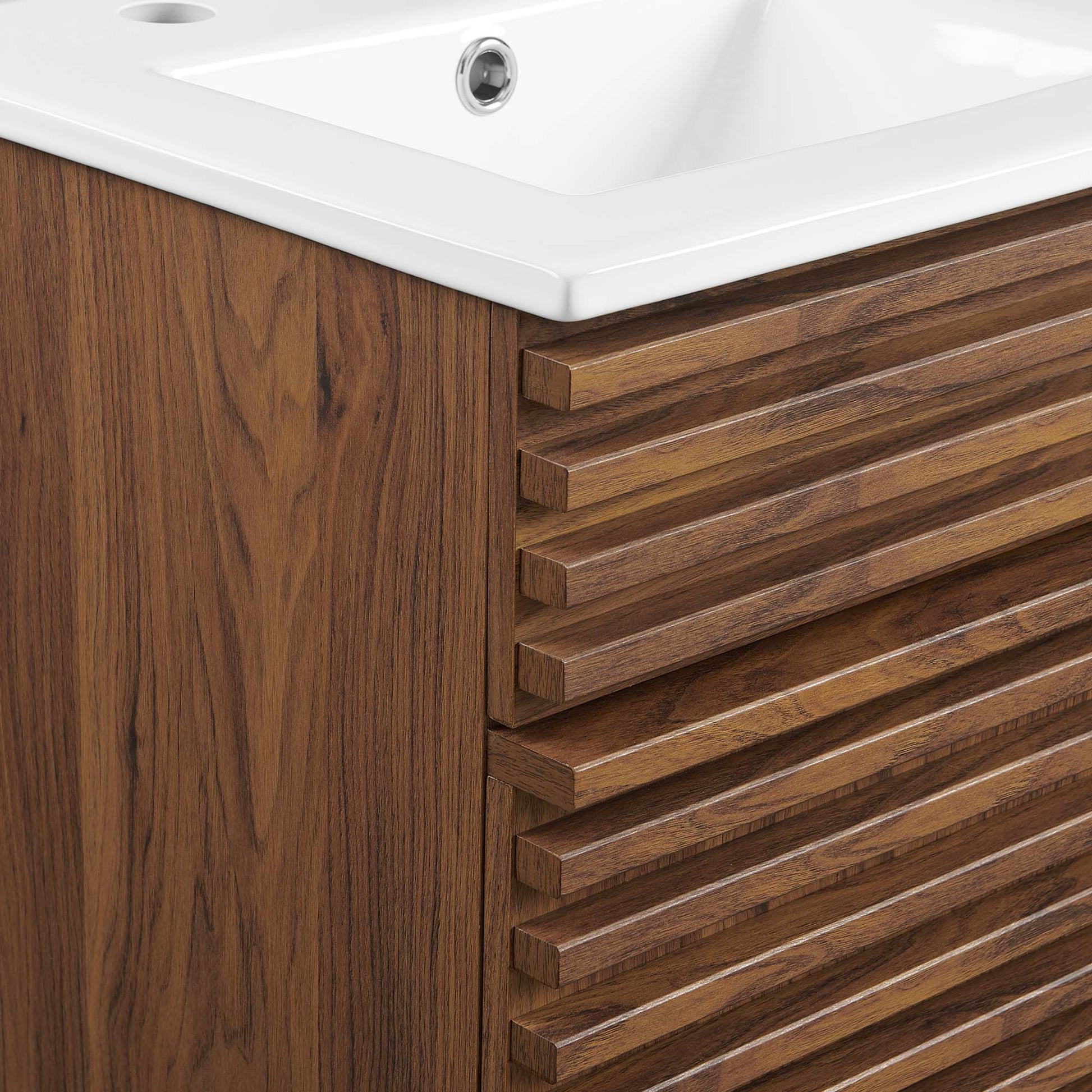 Walnut wood bathroom vanity with horizontal slatted drawers and a white ceramic sink top.