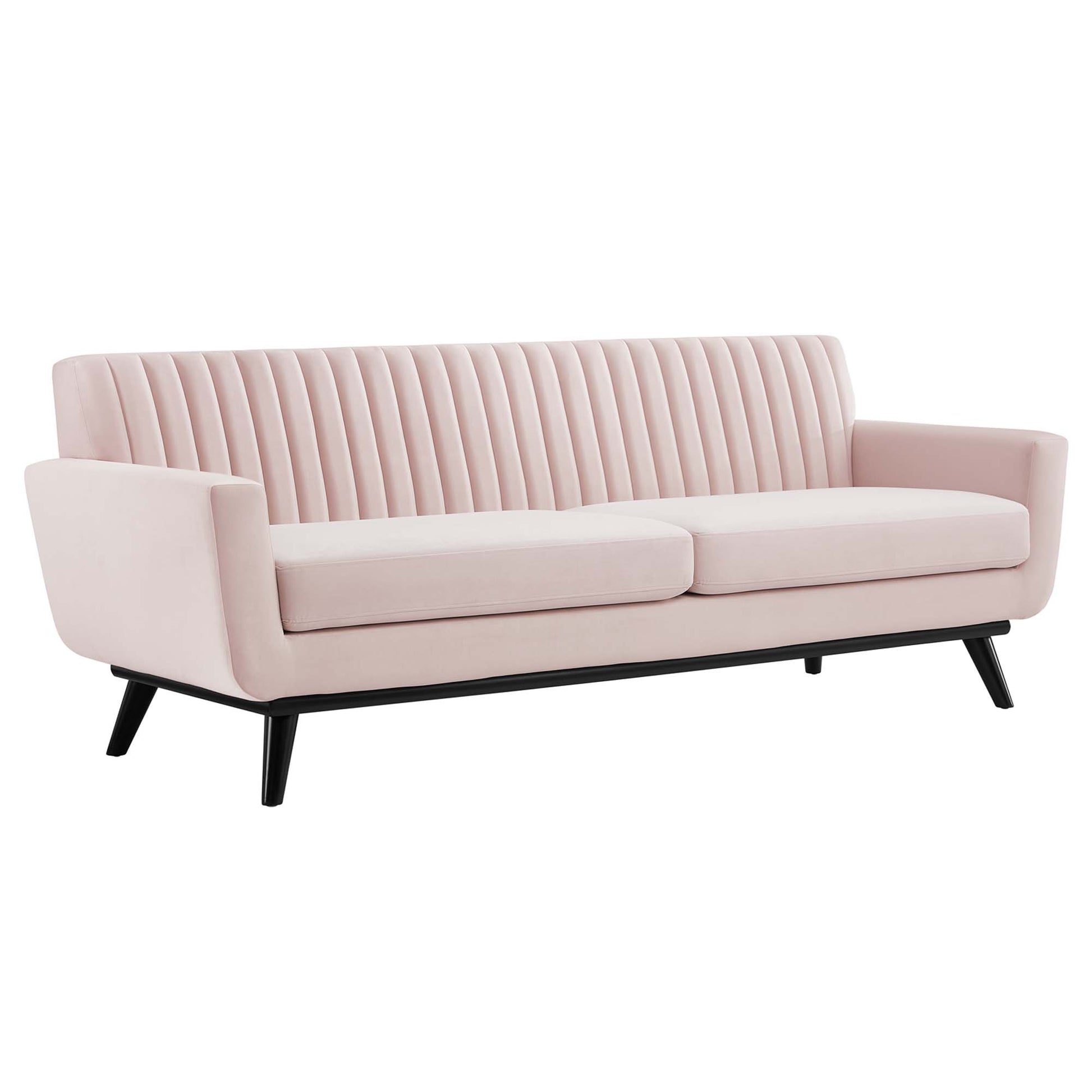Pink velvet sofa with vertical channel-tufted back, two cushions, black angled legs, mid-century modern style.