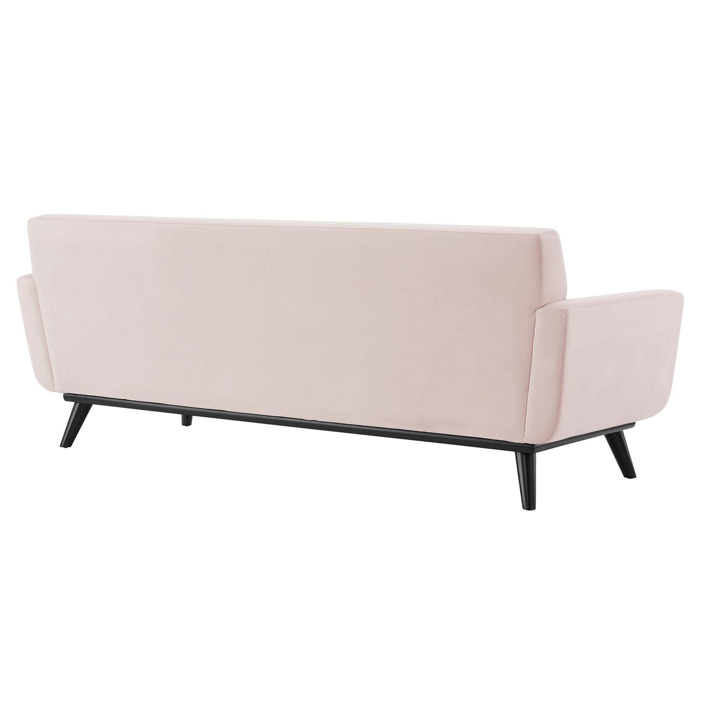 Back view of blush pink upholstered sofa with rectangular arms, black tapered legs, mid-century modern style.