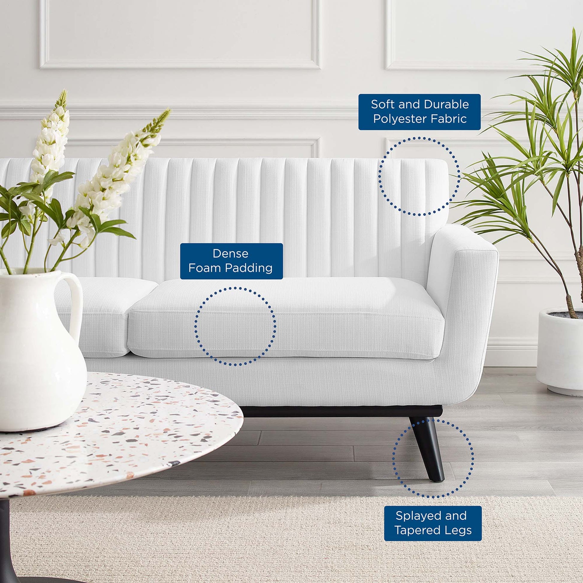White loveseat with dense foam padding, soft durable polyester fabric, and splayed, tapered legs in a modern living room.