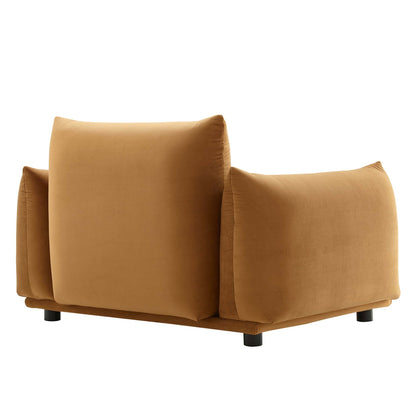 Cognac velvet armchair with oversized square back cushions and short black legs.