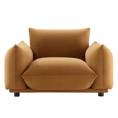 Cognac-brown plush velvet armchair with oversized rounded arms and thick seat cushion, modern lounge style.