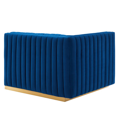 Navy blue velvet left-arm chair with vertical channel tufting and a gold metal base.