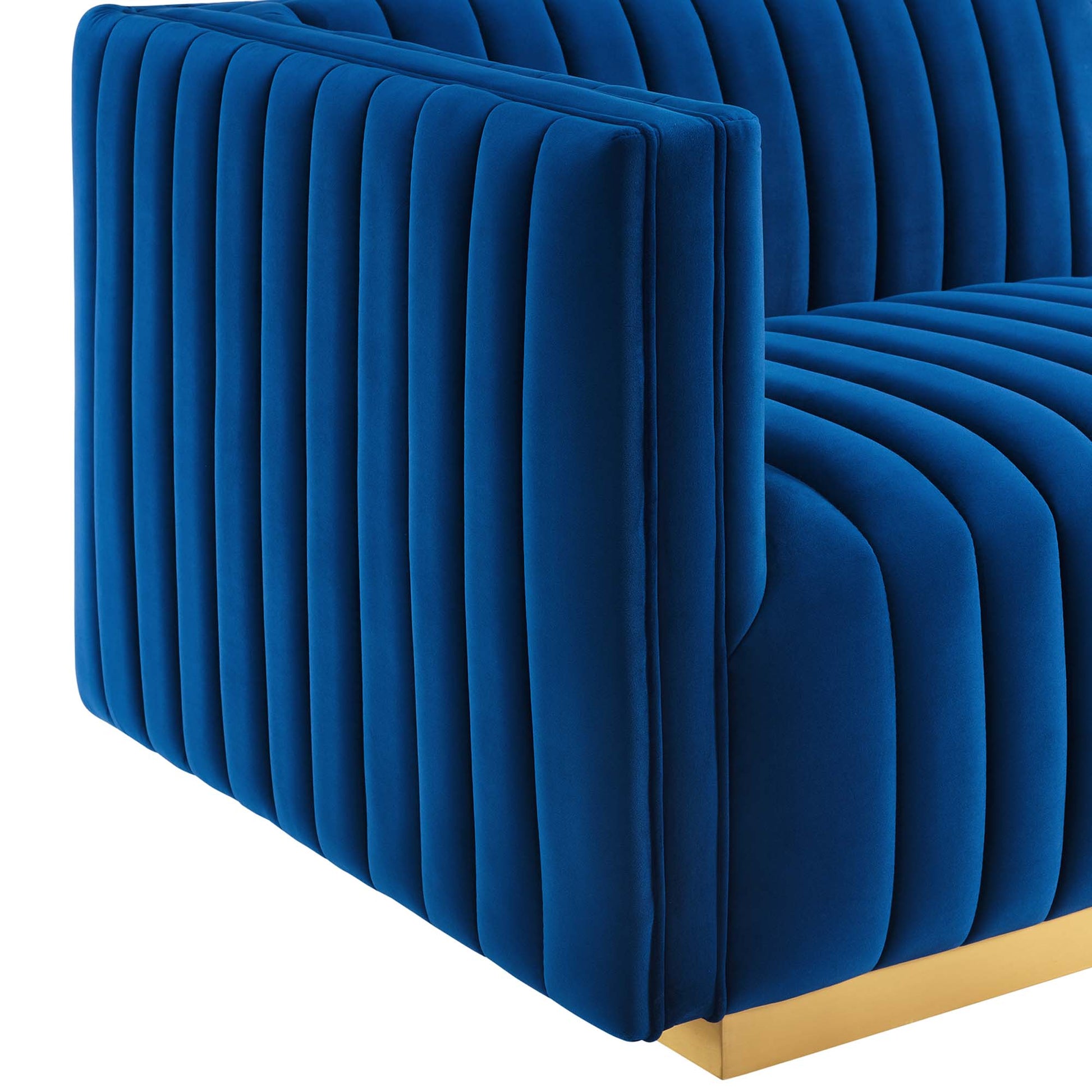 Navy blue velvet left-arm chair with vertical channel tufting, square arms, and a gold metal base.