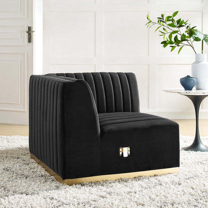 Black velvet channel-tufted right corner chair with gold base in a modern living room.