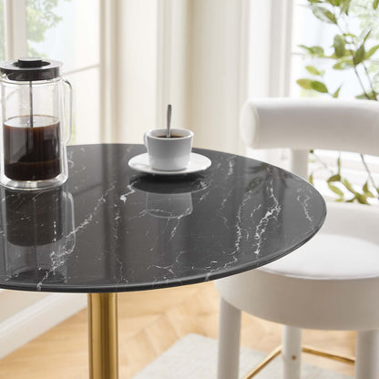 Round black faux marble bar table with a gold pedestal; glass coffee pot and white espresso cup on saucer in a bright modern dining area.
