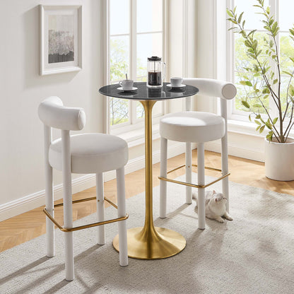 Modern bar table: black round faux-marble top on a gold pedestal in a bright sunlit room.