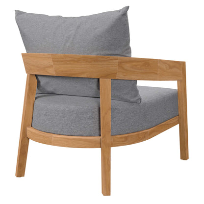 Teak wood outdoor patio armchair with curved seat and grey fabric cushions.