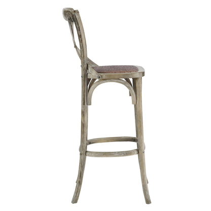 Weathered gray bar stool with woven cane seat, curved back, arched side supports, and circular footrest.